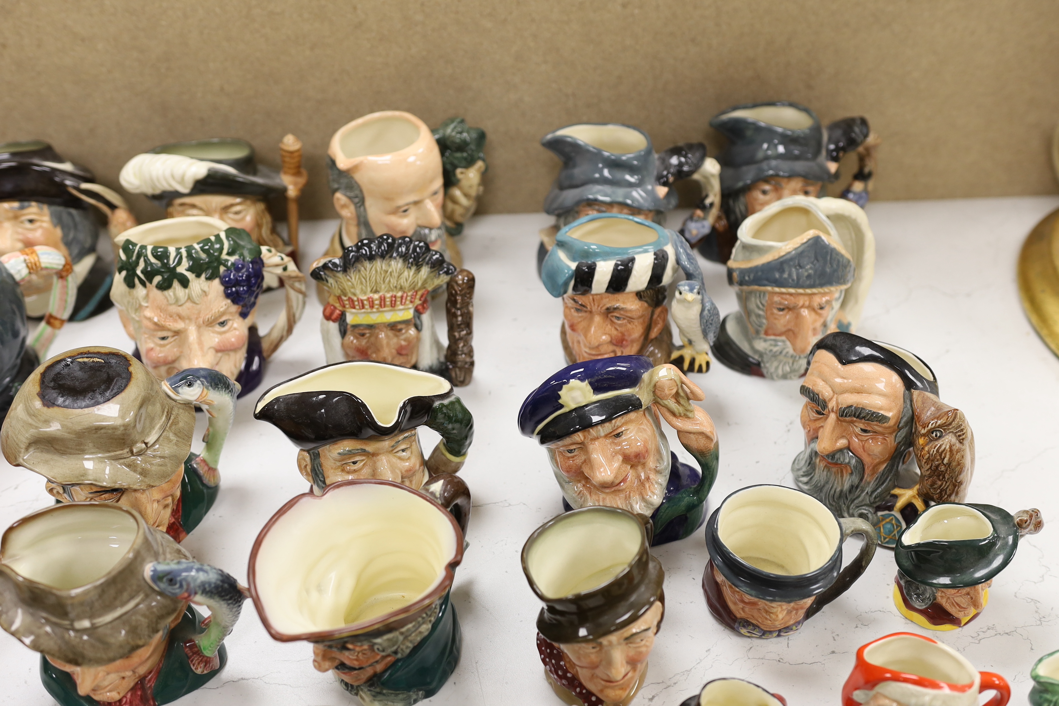 A large collection of Doulton character jugs including the Three Musketeers and Bacchus, largest 10cm high